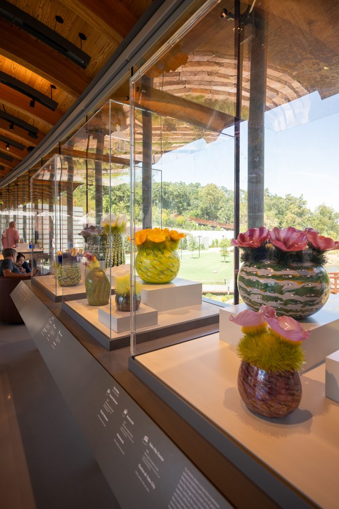 Pottery made of glass in colorful patterns inside of display cases.