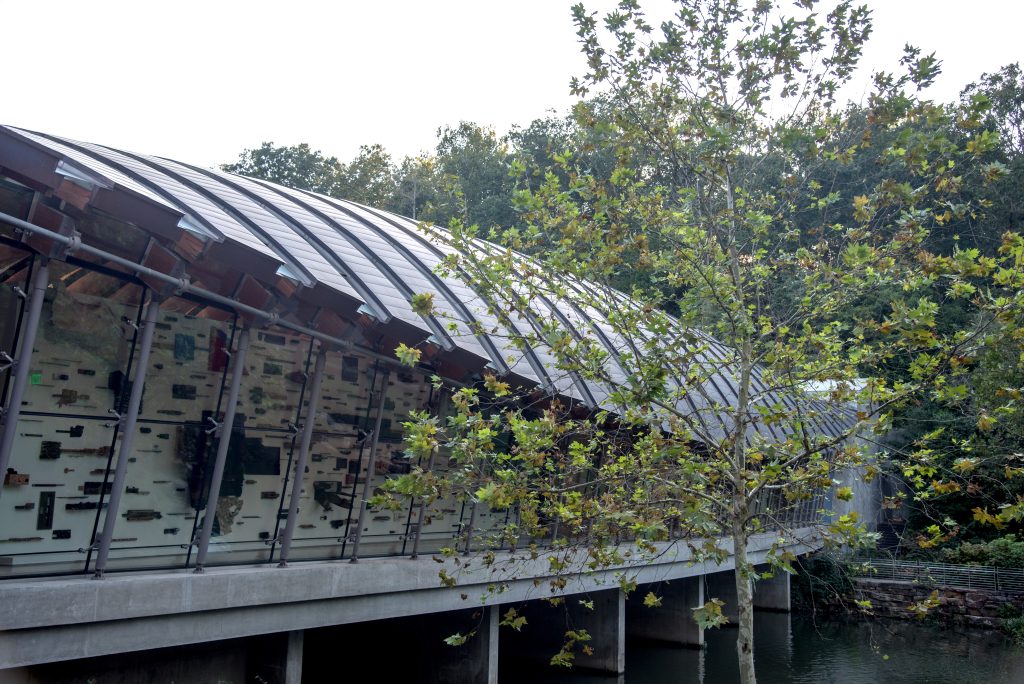 A building with a curved roof over a body of water.