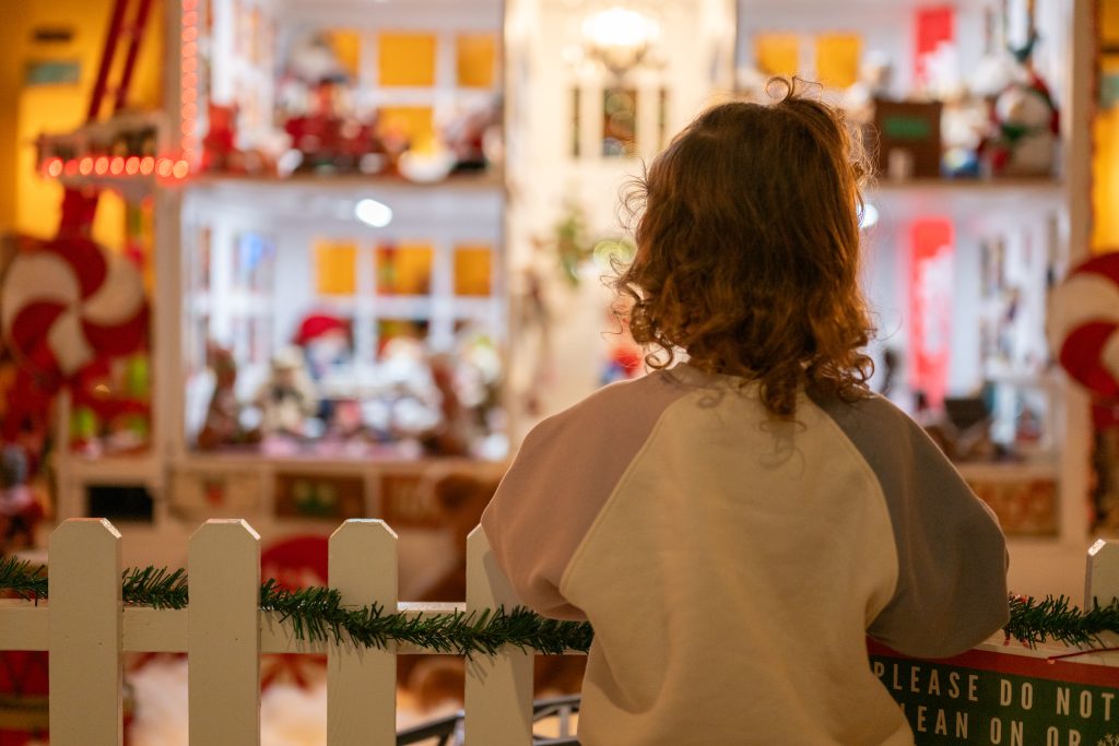 Little girl standing in front of a gingerbread house in the Arlington Hotel in Hot Springs, Arkansas.