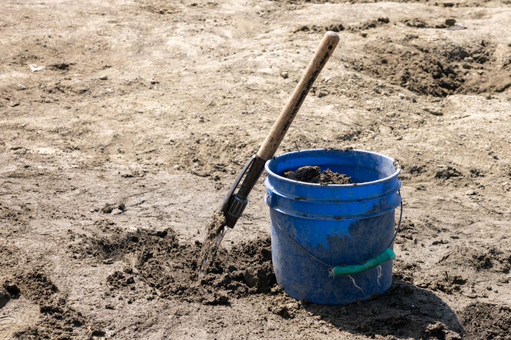 Closeup of a blue bucket with a shovel. This is at Crater of Diamonds State Park in Arkansas. 