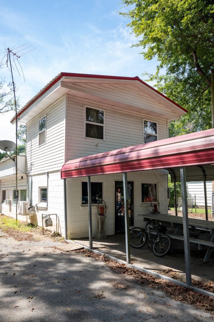 A small two story white building with a red metal awning stretching out front. This is Jones Bar-B-Q diner in the Arkansas Delta. 