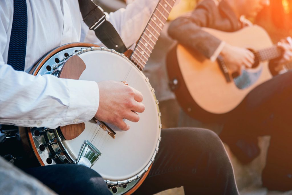 A close up of a banjo and a guitar with people playing them. Bluegrass festival in Arkansas in November. 