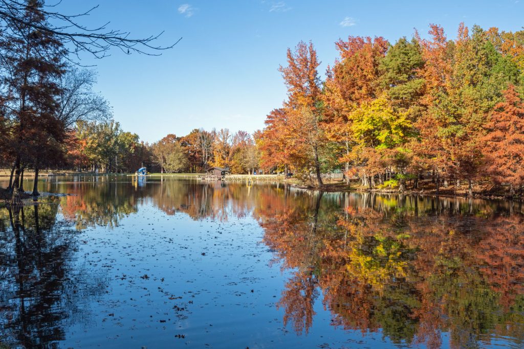 Looking across a lake to a swimming beach and a playground. 