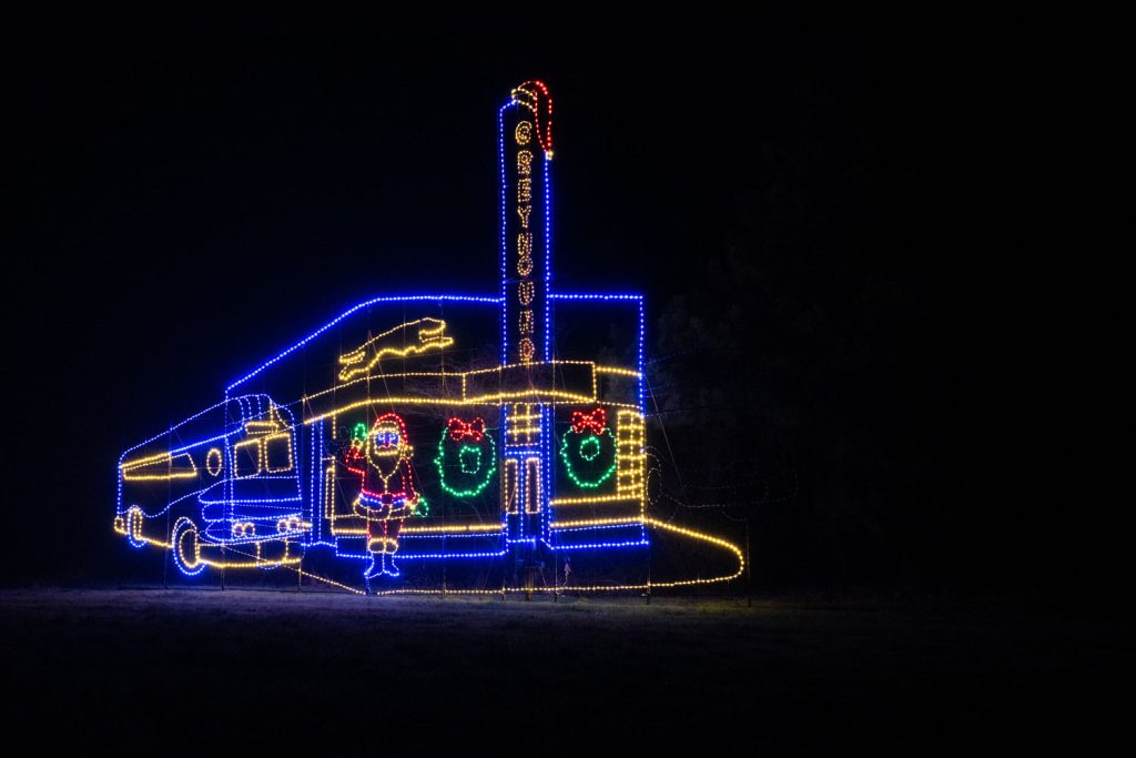 A light display of an old greyhound bus station with a bus and Santa Claus in front. This is at lights of the Delta in Mississippi County Arkansas.
