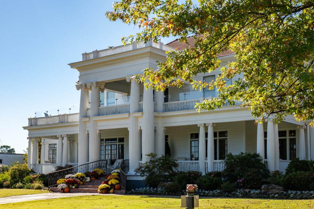 A grand boutique hotel. painted white with large columns.