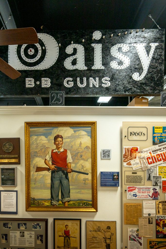 A sign advertising Daisy BB guns with other memorabilia.