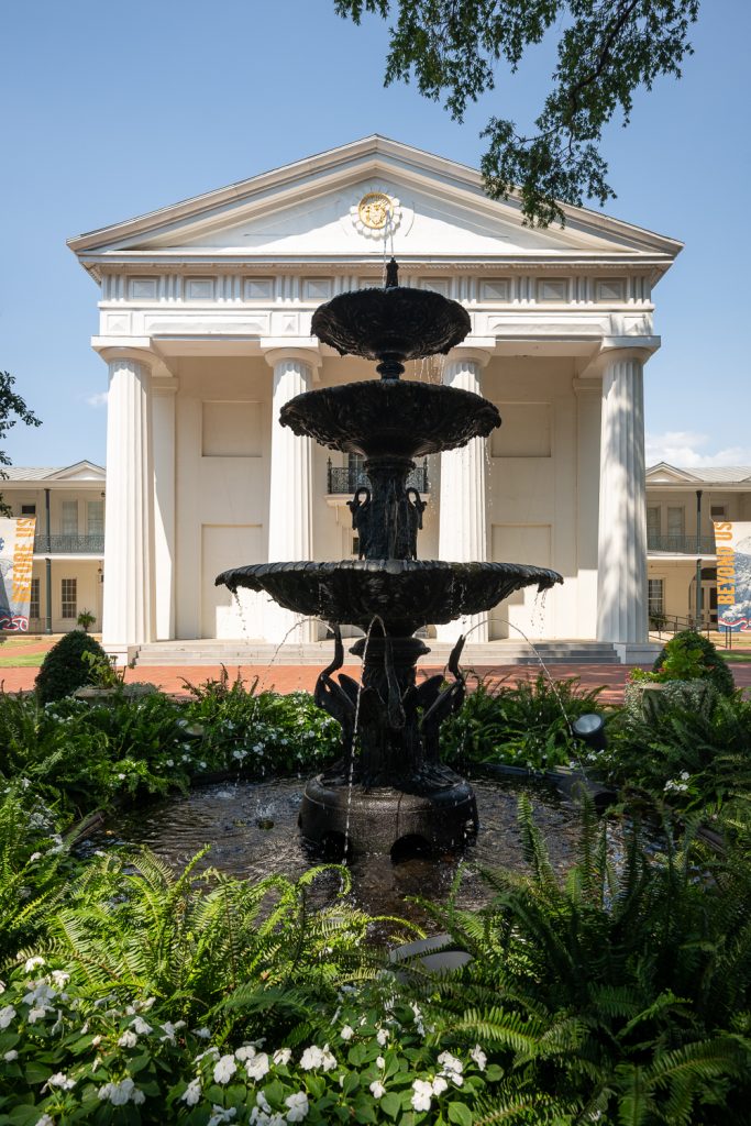 Fountain in front of a large white columned building