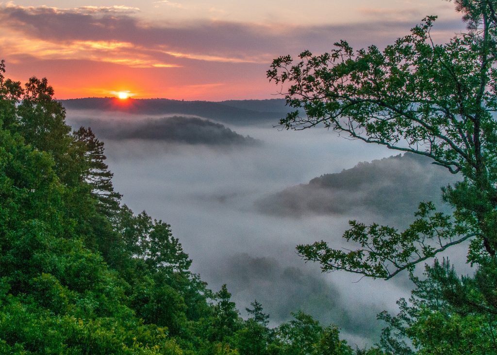 Sunset View in the Ozarks with dense fog over a river in the valley.