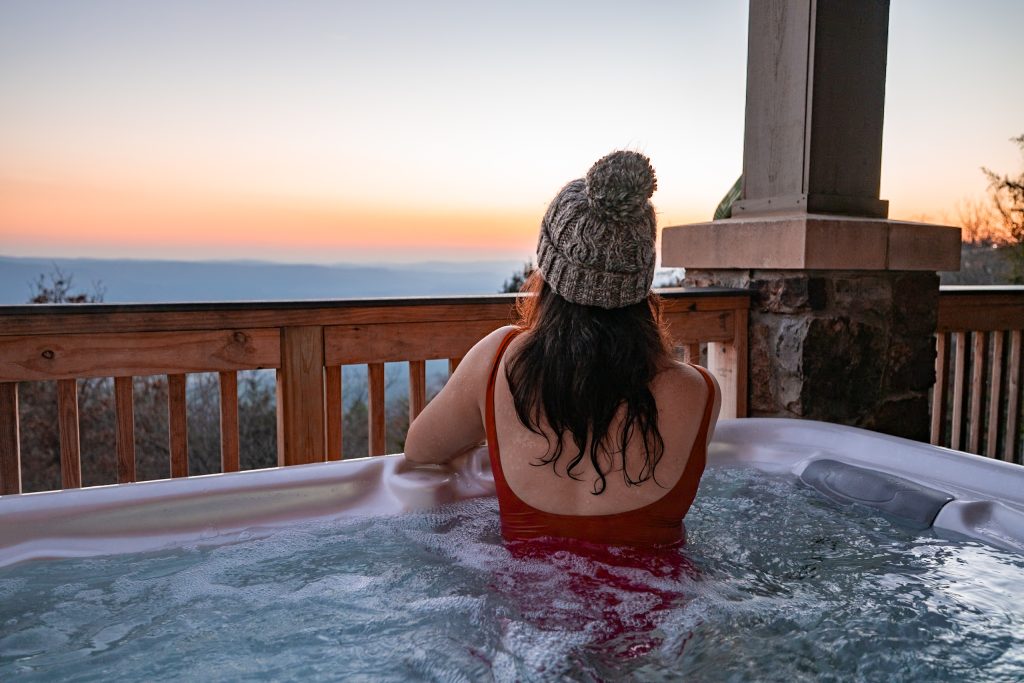 Young woman in a hot tub at a cabin in Arkansas.
